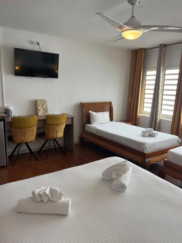 a hotel room with two beds and a couch at Hôtel Les Embruns Du Baril in Basse Vallée
