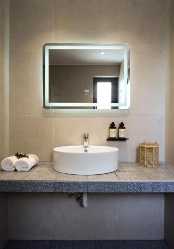 a sink in a bathroom with a mirror and towels at Falena Luxury Rooms in Kalyves Poligirou