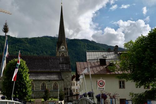 an old church with a clock tower in a town at Haus Maria in Bruck an der Großglocknerstraße