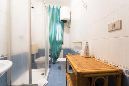 Un baño con ducha, lavabo e inodoro. en Casa Penelope, en Favignana