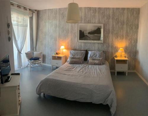 - une chambre avec un lit, deux lampes et une chaise dans l'établissement Appartement plein centre de La Teste-de-Buch, à La Teste-de-Buch