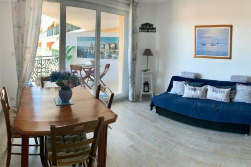 un salon avec un canapé bleu et une table dans l'établissement Appartement plein centre de La Teste-de-Buch, à La Teste-de-Buch