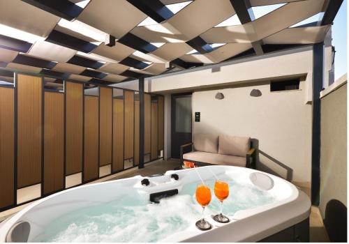 uma banheira com dois copos de vinho em CORYLUS Luxury Rooms & Suites em Leptokarya