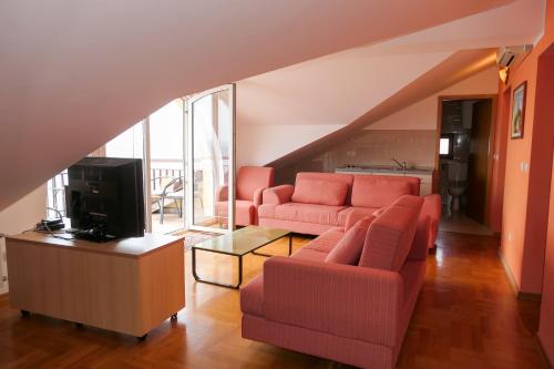 - un salon avec un canapé et une télévision dans l'établissement Apartmani Ivanka Prpić, à Senj