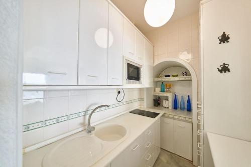 a white kitchen with a sink and a counter at Arriate in San José