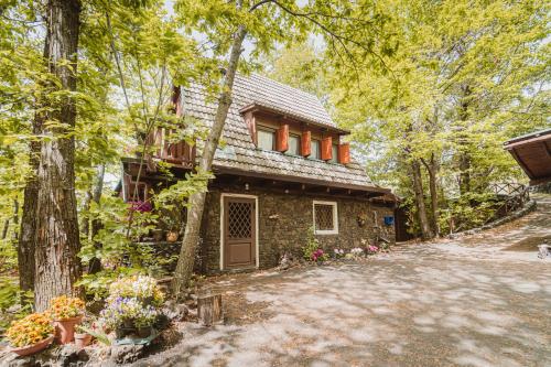 a stone house in the woods with flowers at Matilde's Chalet Etna Nature House in Nicolosi