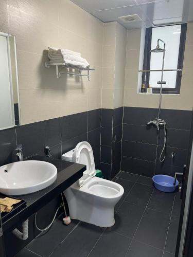 a bathroom with a white toilet and a sink at Lux Hotel FLC Sầm Sơn in Sầm Sơn