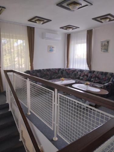 a waiting room with a couch and two sinks at Kokó Panzió in Harkány