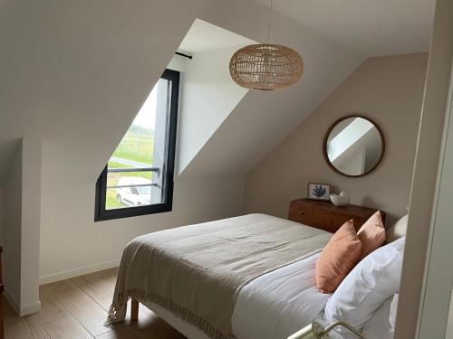 sypialnia z łóżkiem, oknem i lustrem w obiekcie Villa Beau Séjour w mieście Fontenay-sur-Mer