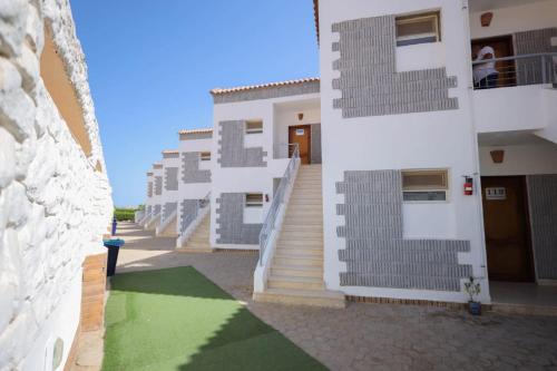 una fila de edificios con escaleras y un suelo verde en Andalusia Blue Beach Hurghada en Hurghada
