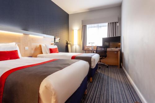 ein Hotelzimmer mit 2 Betten und einem Schreibtisch in der Unterkunft Holiday Inn Express Edinburgh – Royal Mile, an IHG Hotel in Edinburgh