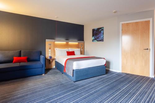 a hotel room with a bed and a couch at Holiday Inn Express Edinburgh – Royal Mile by IHG in Edinburgh