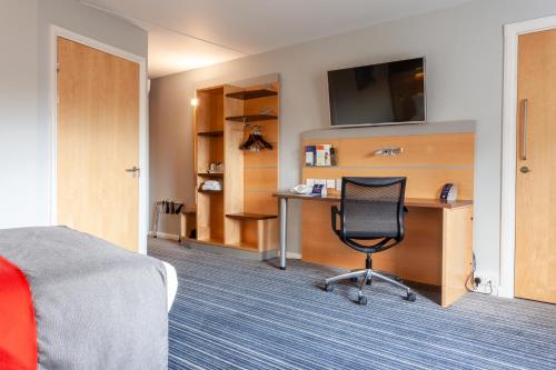 a hotel room with a desk and a chair at Holiday Inn Express Edinburgh – Royal Mile by IHG in Edinburgh