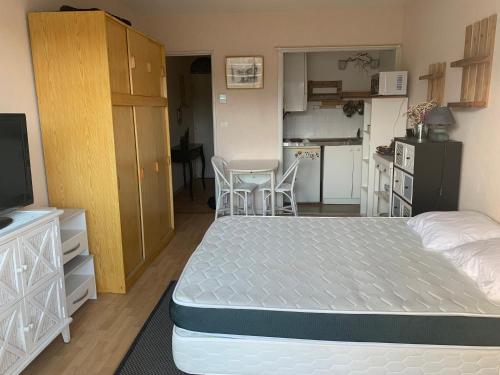 une petite chambre avec un lit et une cuisine dans l'établissement Studio Centre Ville, à Arcachon