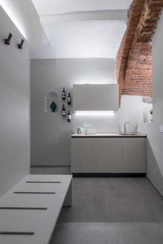 a kitchen with white cabinets and a brick wall at Ca' Amae Portovener e in Portovenere