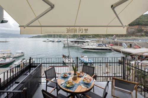 Ca' Amae Portovener e في بورتوفينيري: طاولة طعام على شرفة مع قوارب في الماء
