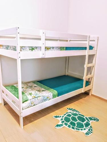 a white bunk bed in a room with a turtle rug at La Stella Marina in Porto Recanati