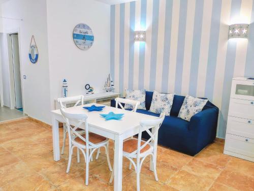 a living room with a table and a blue couch at La Stella Marina in Porto Recanati