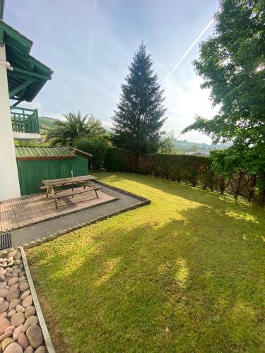un parc avec un banc de pique-nique dans l'herbe dans l'établissement Studio entre mer et montagnes, à Louhossoa