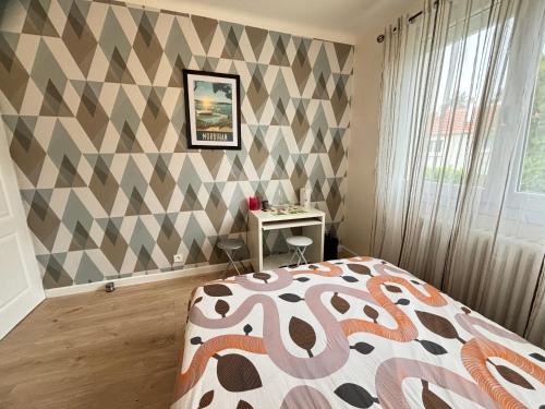 a bedroom with a bed and a checkered wall at La Maison du Bonheur in Saint-Herblain