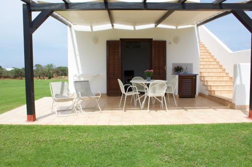 a patio with a table and chairs and stairs at Le Casette a Favignana in Favignana