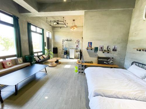 a room with two beds and a table and a couch at 隱月民宿 in Hengchun South Gate