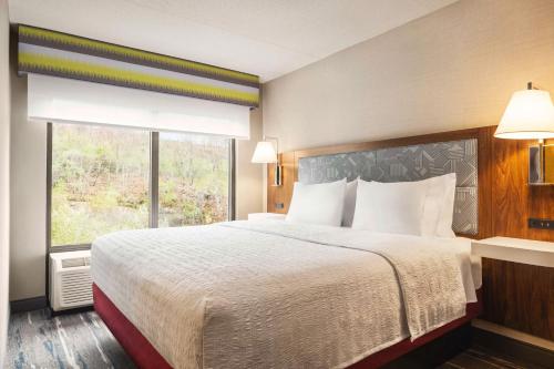 Hampton by Hilton Shelton في شيلتون: غرفة نوم بسرير كبير مع نافذة كبيرة