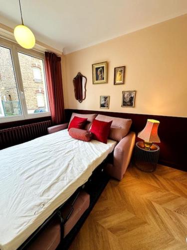 - une chambre avec un lit doté d'oreillers rouges et d'un canapé dans l'établissement La Vie en Rose - Rennes & Gare, à Rennes