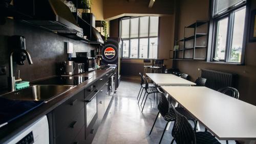 a kitchen with tables and chairs in a restaurant at Nordic Hostel in Reykjavík