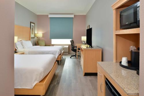 a hotel room with two beds and a desk at Hilton Garden Inn Denton in Denton