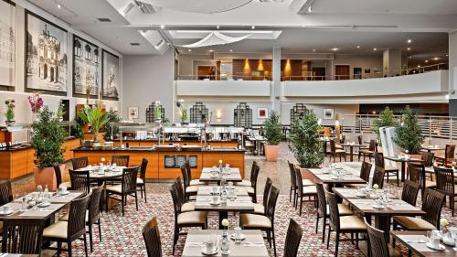 a dining room with tables and chairs and a restaurant at Hilton Dresden an der Frauenkirche in Dresden