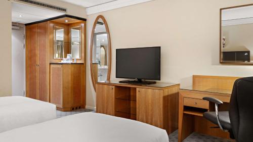 a bedroom with a bed and a television on a desk at Hilton Dresden an der Frauenkirche in Dresden