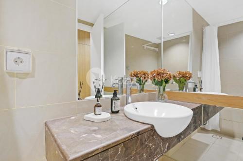 ein Badezimmer mit Waschbecken und Spiegel in der Unterkunft Vesta by Kozystay - Gandaria in Jakarta