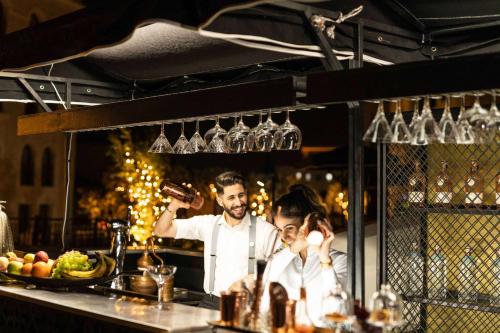 a man and a woman standing behind a bar at Waldorf Astoria Jerusalem in Jerusalem