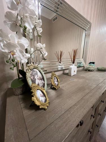 eine Kommode mit Spiegel und ein paar Blumen drauf in der Unterkunft Yas Island in Abu Dhabi