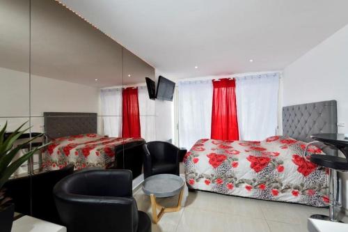 - une chambre avec 2 lits et des rideaux rouges dans l'établissement Studio ANITA- Héliopolis F 76 - Chic - 2 personnes, au Cap d'Agde