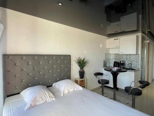 une chambre avec un lit et une petite cuisine dans l'établissement Studio ANITA- Héliopolis F 76 - Chic - 2 personnes, au Cap d'Agde