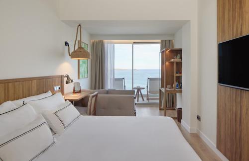 a hotel room with a bed and a living room at Melia Ibiza - Adults Only in Santa Eularia des Riu