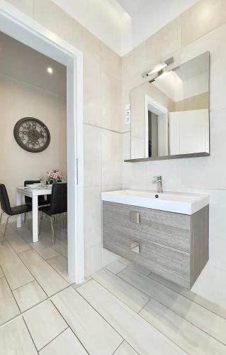 a bathroom with a sink and a mirror and a table at Trigon Palace in Budapest