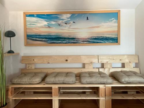 a wooden bench in a room with a painting on the wall at LA HALTE du MONTALIEU in Eysines