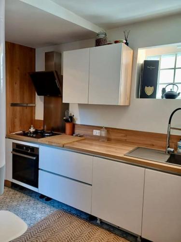 une cuisine avec des armoires blanches et un comptoir dans l'établissement Charmant 3pièces près de Cannes, au Cannet