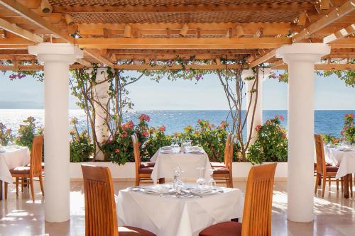 a restaurant with tables and chairs with the ocean in the background at Steigenberger Hotel & Nelson Village, Taba in Taba