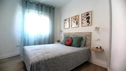 a bedroom with a bed with green pillows and a window at San Fausto in Aguadulce