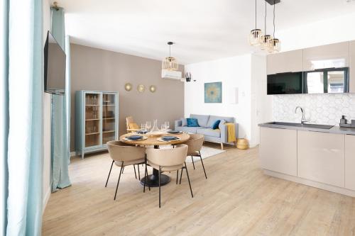 a kitchen and dining room with a table and chairs at Le Flourens by Paul Riquet 1609 Residences in Béziers