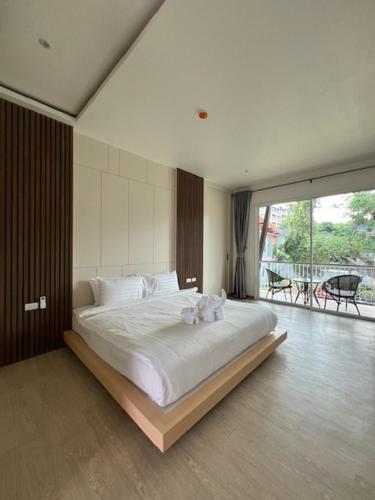 a bedroom with a large bed and a balcony at Tommy Resort2 in Haad Rin
