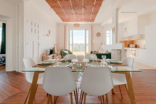 une salle à manger avec une table et des chaises blanches dans l'établissement Appartement Spacieux - Vue Pyrénées - Hypercentre, à Tarbes