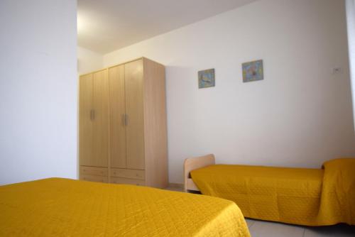 um quarto com 2 camas e um cobertor amarelo em La Marina 2 em Marina di Campo