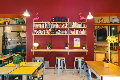 een restaurant met tafels en planken met boeken bij Ostello Bello Milano Centrale in Milaan