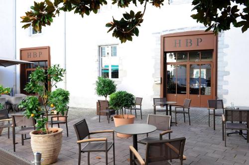 a patio with tables and chairs in front of a building at H&ocirc;tel des Basses Pyr&eacute;n&eacute;es - Bayonne in Bayonne