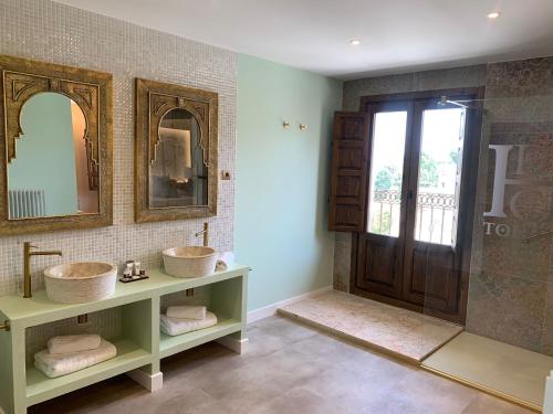 uma casa de banho com 2 lavatórios e um espelho em Hotel Hacienda del Cardenal em Toledo